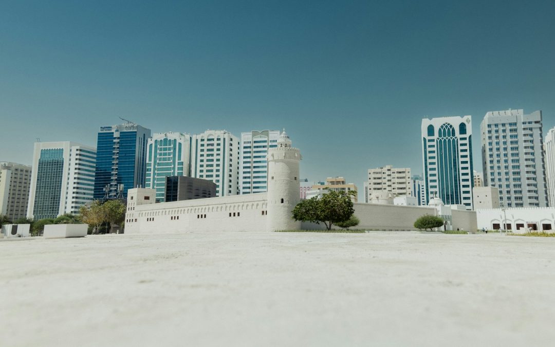 a large white building with a lot of tall buildings in the background Qasr Al Hosn